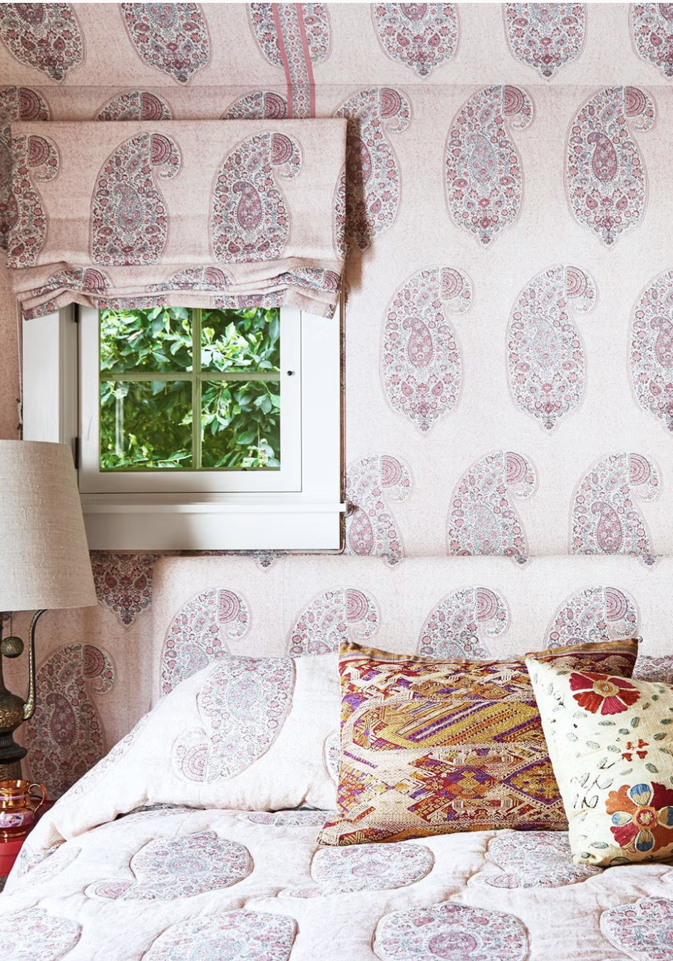The matchy-matchy pink paisley window treatments, wallpaper, curtains, bedding, and headboard create a gorgeous backdrop for a good night's sleep